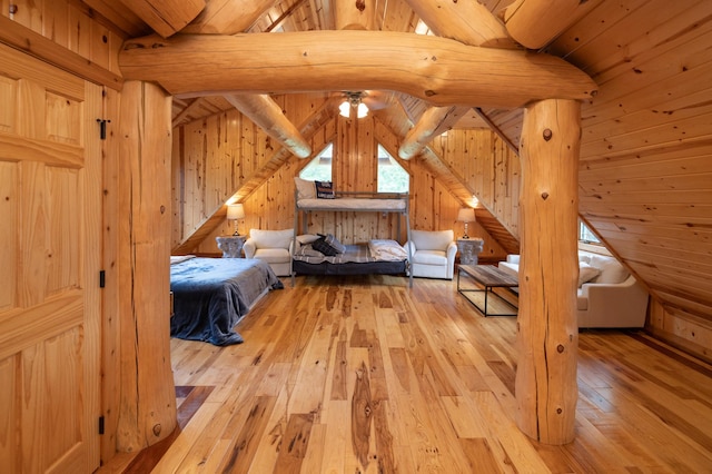 unfurnished bedroom featuring lofted ceiling, wooden walls, and light hardwood / wood-style floors