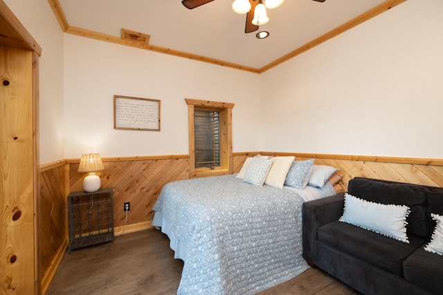 bedroom with ceiling fan, ornamental molding, and dark wood-type flooring