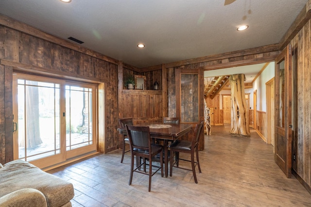 dining room with wooden walls and hardwood / wood-style floors