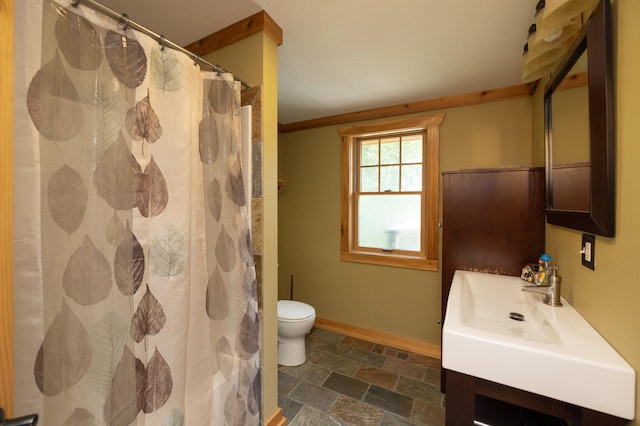 bathroom with toilet, vanity, and ornamental molding