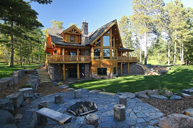 back of property featuring a patio, a yard, a fire pit, and a wooden deck