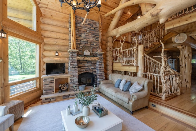 living room featuring hardwood / wood-style flooring, log walls, a fireplace, wooden ceiling, and beamed ceiling