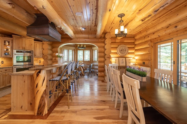 dining space featuring light wood-type flooring, log walls, plenty of natural light, and beam ceiling