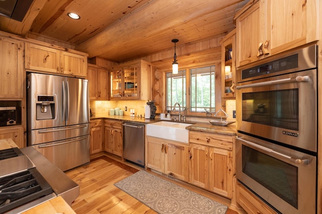 kitchen featuring sink, light hardwood / wood-style flooring, pendant lighting, wood ceiling, and appliances with stainless steel finishes