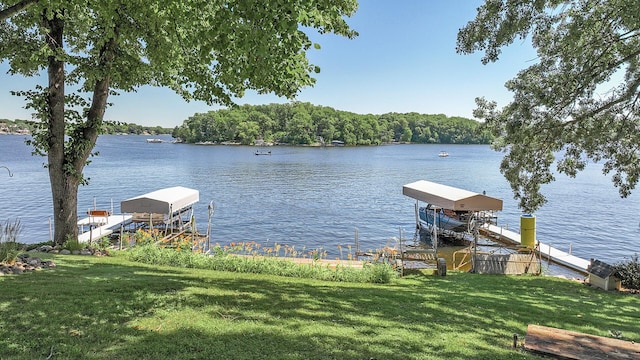 view of dock featuring a water view and a yard