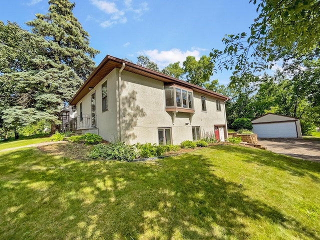 view of front facade featuring a front yard, a garage, and an outdoor structure