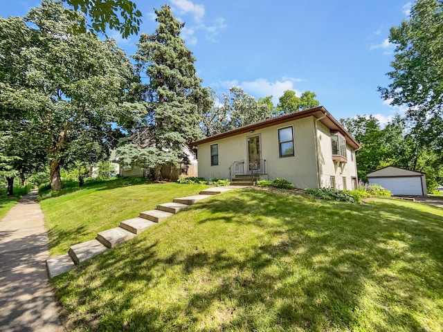 view of front of home featuring an outbuilding, a garage, and a front yard