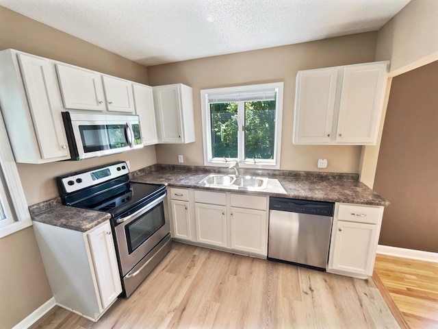 kitchen with light wood-type flooring, white cabinetry, sink, and stainless steel appliances