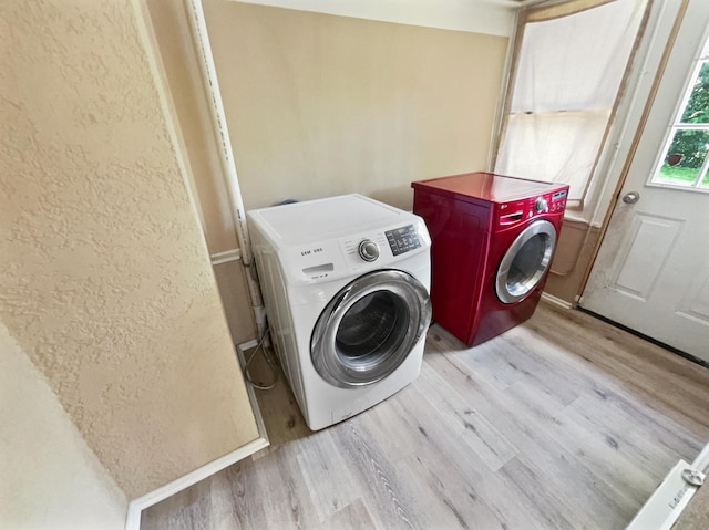 laundry room featuring separate washer and dryer and light wood-type flooring