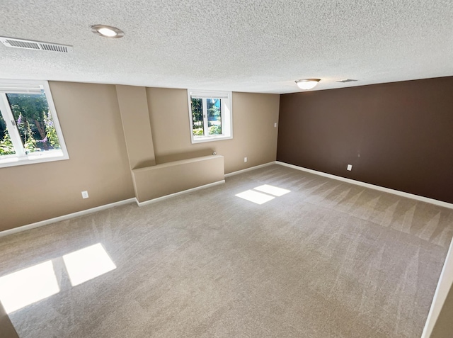 carpeted spare room with a textured ceiling