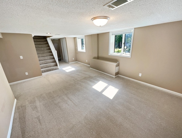 interior space featuring light colored carpet and a textured ceiling