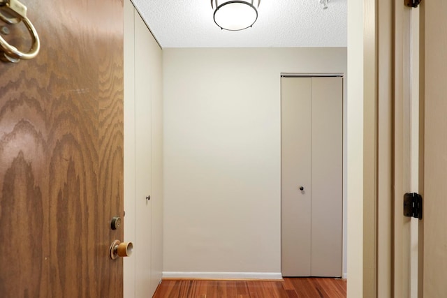 hall featuring hardwood / wood-style flooring and a textured ceiling