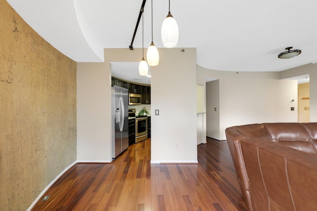 kitchen with decorative light fixtures, dark wood-type flooring, and stainless steel appliances