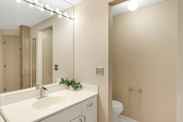 bathroom featuring a textured ceiling, toilet, and vanity