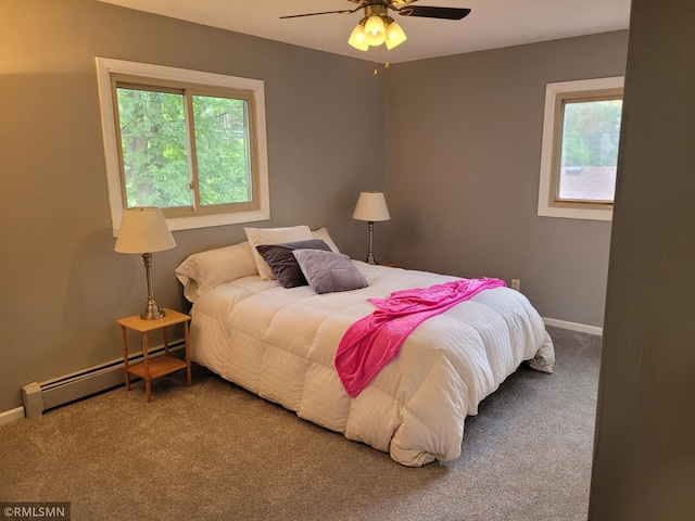 bedroom with a baseboard heating unit, carpet, multiple windows, and ceiling fan