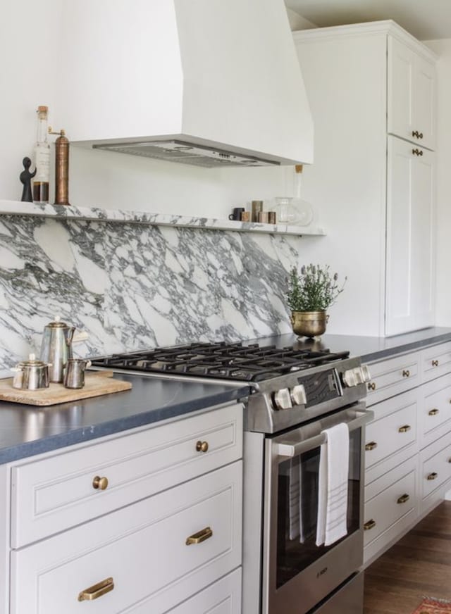 kitchen with double oven range, white cabinets, decorative backsplash, custom range hood, and dark hardwood / wood-style floors