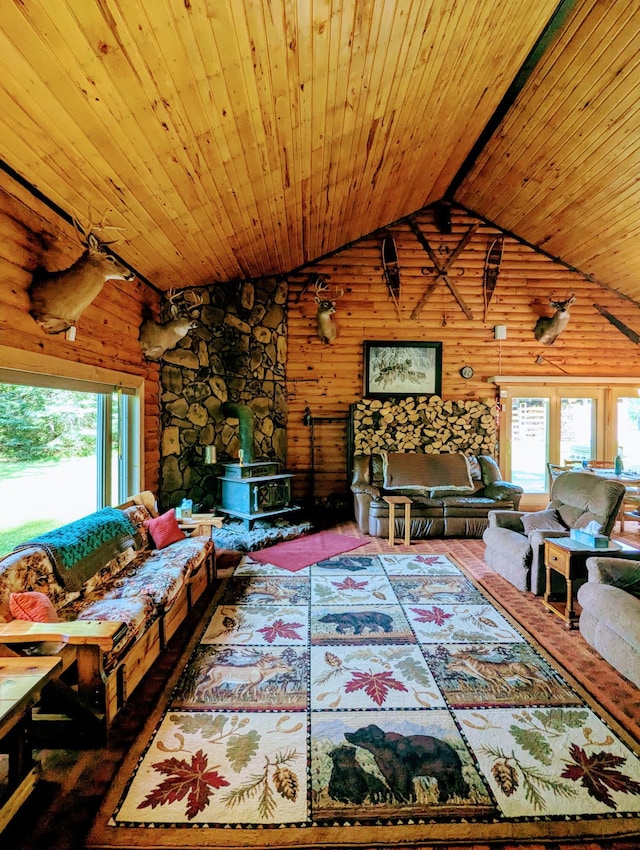 unfurnished living room featuring beam ceiling, wooden walls, a wood stove, wooden ceiling, and high vaulted ceiling