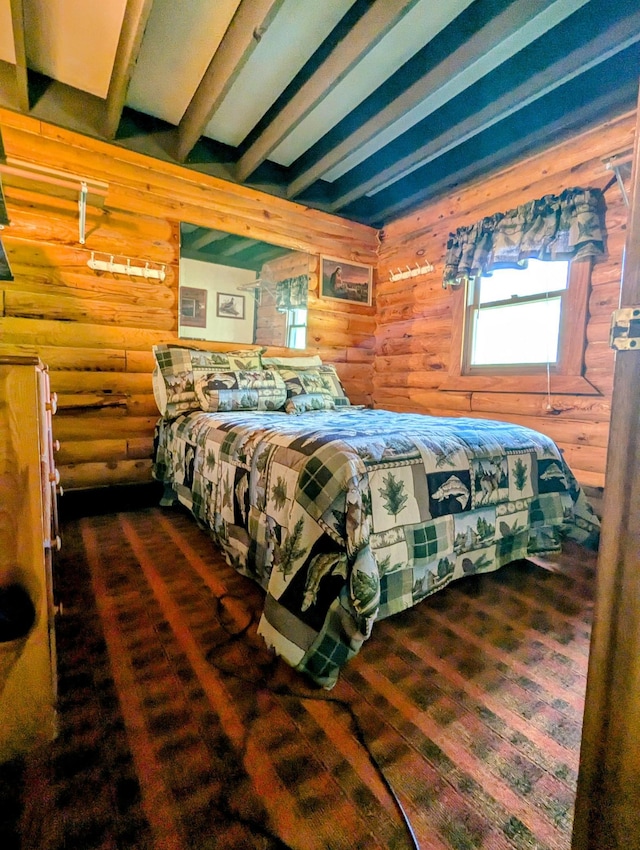 bedroom with log walls and beamed ceiling