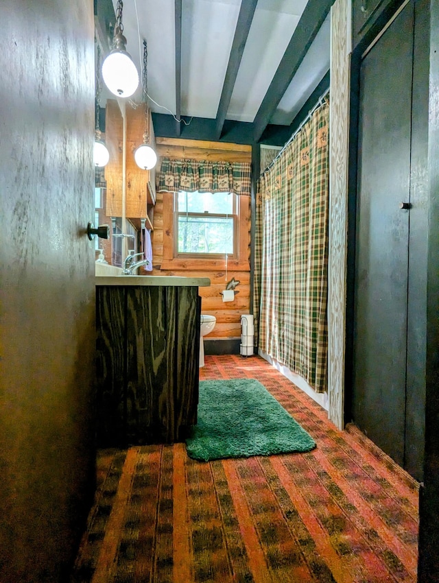 bathroom with toilet and beamed ceiling