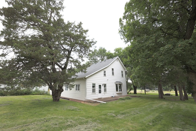 view of property exterior with a patio and a lawn