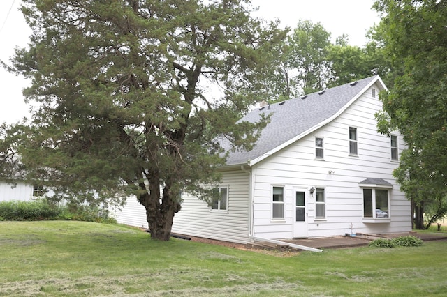 rear view of house featuring a yard