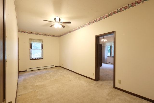 spare room featuring light colored carpet, ceiling fan with notable chandelier, and a baseboard heating unit