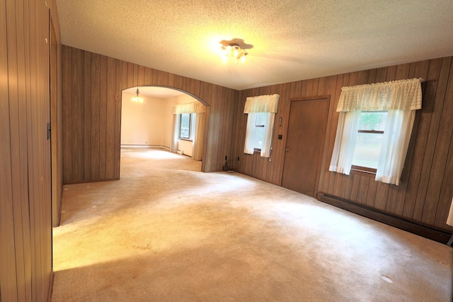 unfurnished room with wooden walls and light carpet