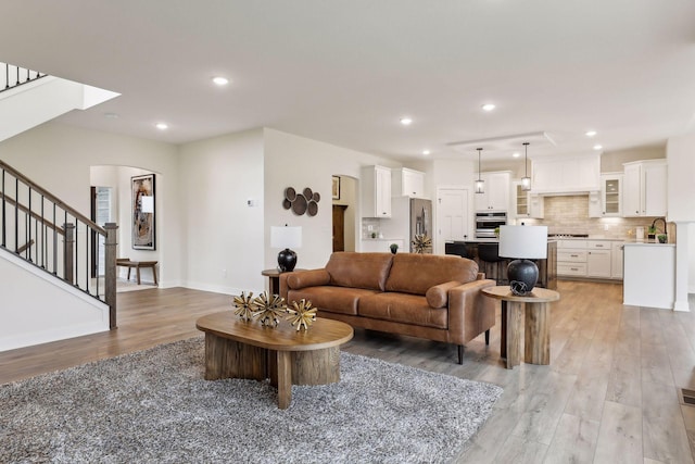 living room with sink and light hardwood / wood-style flooring