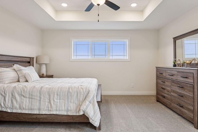 bedroom featuring ceiling fan, carpet, and a tray ceiling