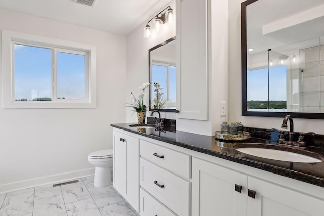 bathroom featuring plenty of natural light, toilet, vanity, and an enclosed shower