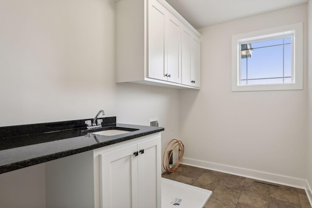 laundry area with sink, hookup for a washing machine, and cabinets