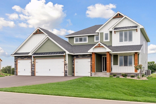 view of front of house featuring a shingled roof, board and batten siding, a front yard, a standing seam roof, and driveway