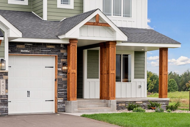 doorway to property featuring a porch and a garage