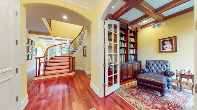 living area with crown molding, coffered ceiling, beamed ceiling, and hardwood / wood-style floors