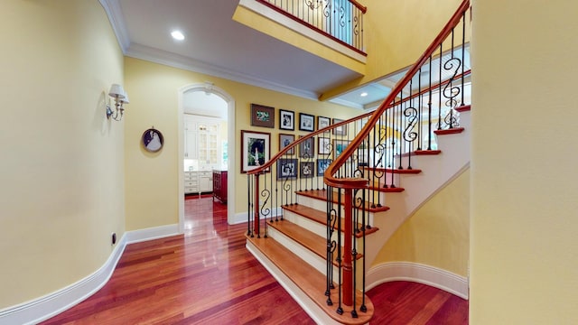 stairway featuring hardwood / wood-style flooring and ornamental molding