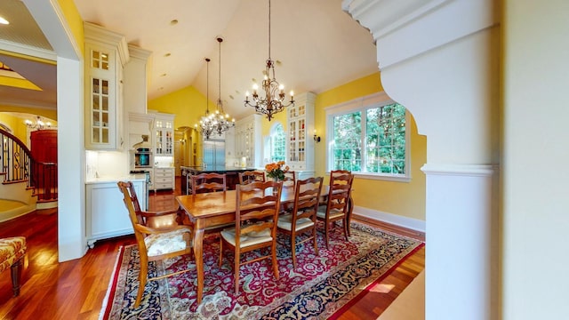 dining space featuring hardwood / wood-style floors, high vaulted ceiling, and a notable chandelier