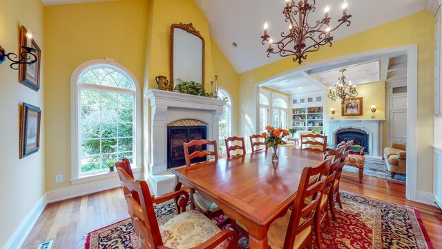 dining area featuring a chandelier, wood-type flooring, and a high ceiling