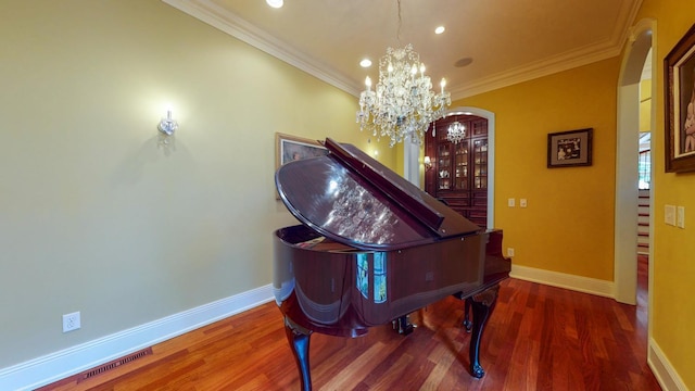 miscellaneous room with dark hardwood / wood-style flooring, an inviting chandelier, and ornamental molding