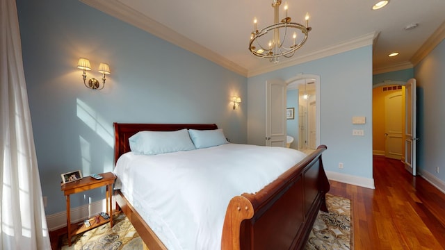 bedroom with ornamental molding, an inviting chandelier, and dark hardwood / wood-style floors