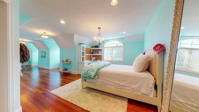 bedroom featuring multiple windows, vaulted ceiling, dark wood-type flooring, and a notable chandelier