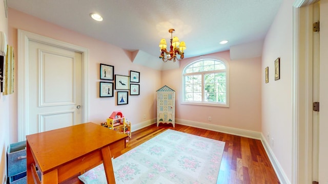 home office with hardwood / wood-style flooring and a notable chandelier