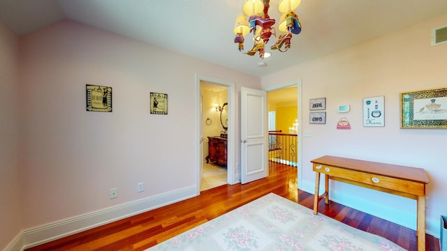 bedroom featuring vaulted ceiling, hardwood / wood-style floors, and ensuite bathroom