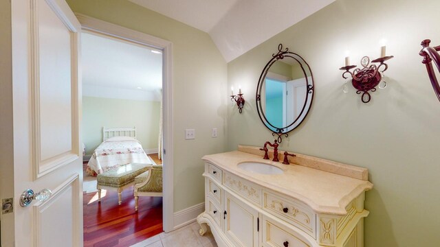 bathroom with vanity, lofted ceiling, and wood-type flooring