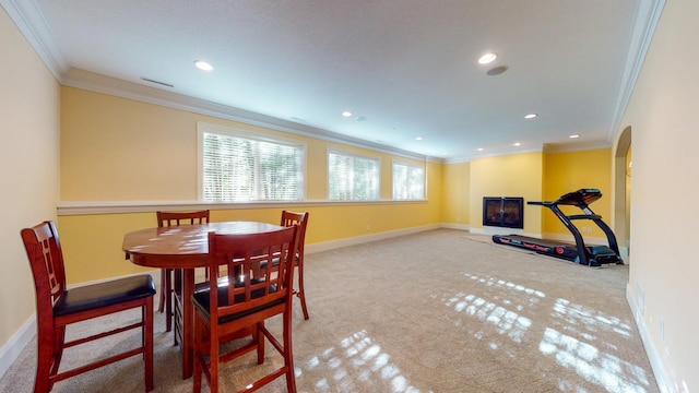 carpeted dining area with crown molding