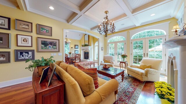 living room featuring crown molding, an inviting chandelier, dark hardwood / wood-style floors, and beam ceiling