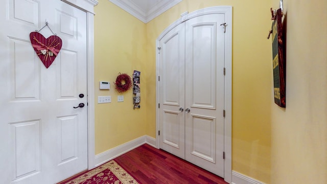 foyer with ornamental molding and dark hardwood / wood-style flooring