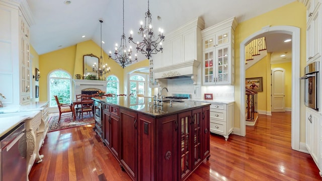 kitchen featuring a kitchen island with sink, pendant lighting, dark hardwood / wood-style flooring, and stainless steel appliances