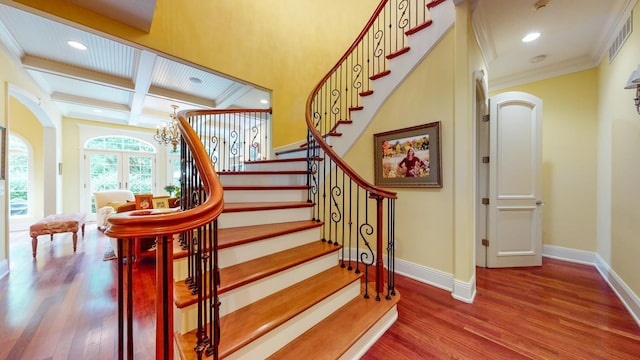 stairs with coffered ceiling, beamed ceiling, crown molding, an inviting chandelier, and hardwood / wood-style flooring