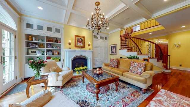 living room with crown molding, coffered ceiling, a chandelier, and hardwood / wood-style floors