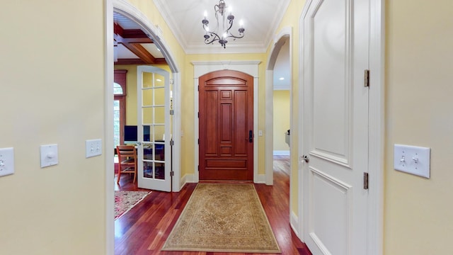 entryway with coffered ceiling, beamed ceiling, a notable chandelier, crown molding, and dark hardwood / wood-style flooring